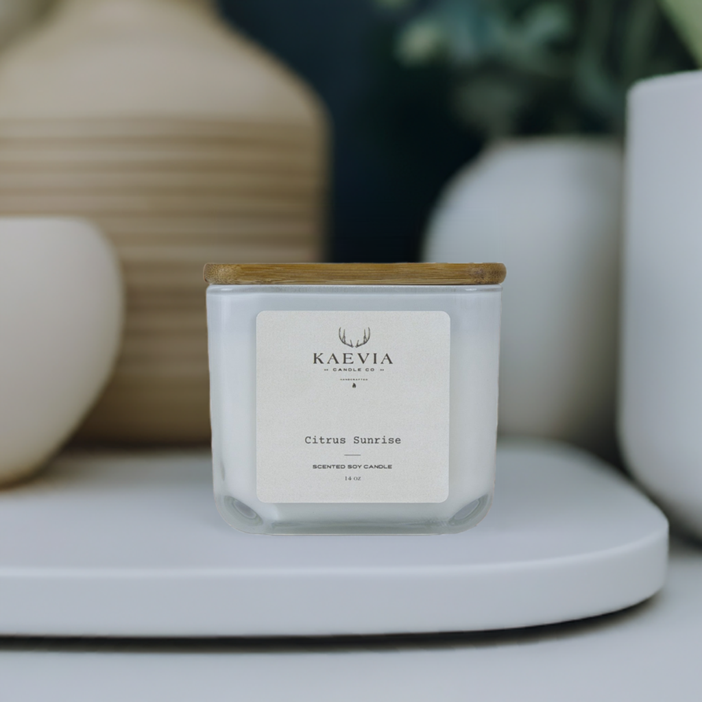 14 oz candle from Kaevia in white cube jar with a wooden lid situated on a table