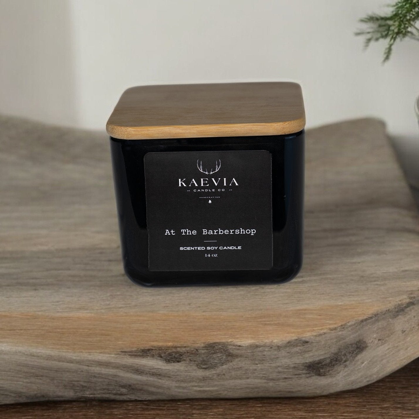 Kaevia Red Stag Trophy candle in a minimalist black jar with a natural lid on a tray
