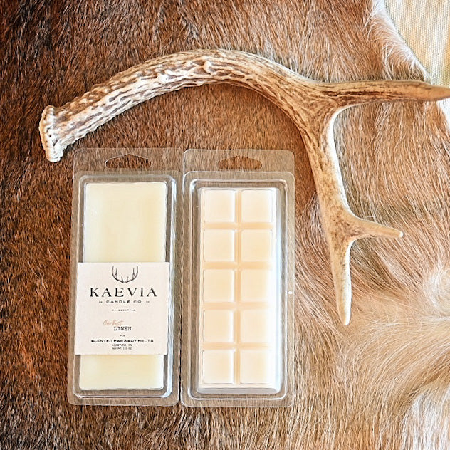 Clamshell packaged scented melts resting on deer-like home decor with deer antlers nearby