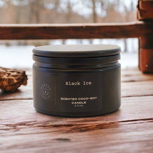 Red Stag Button Buck coconut-soy candle in a black candle jar with black lid sitting on a wood table