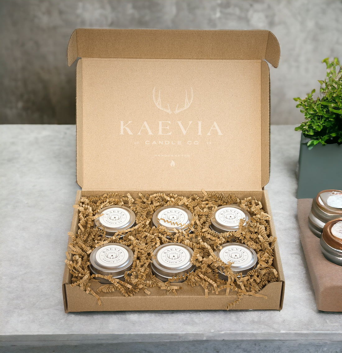 6 small tin jars in a gift boc sitting on a concretetable