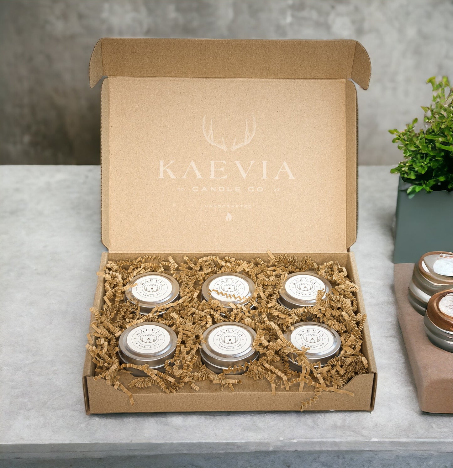 6 small tin jars in a gift boc sitting on a concretetable