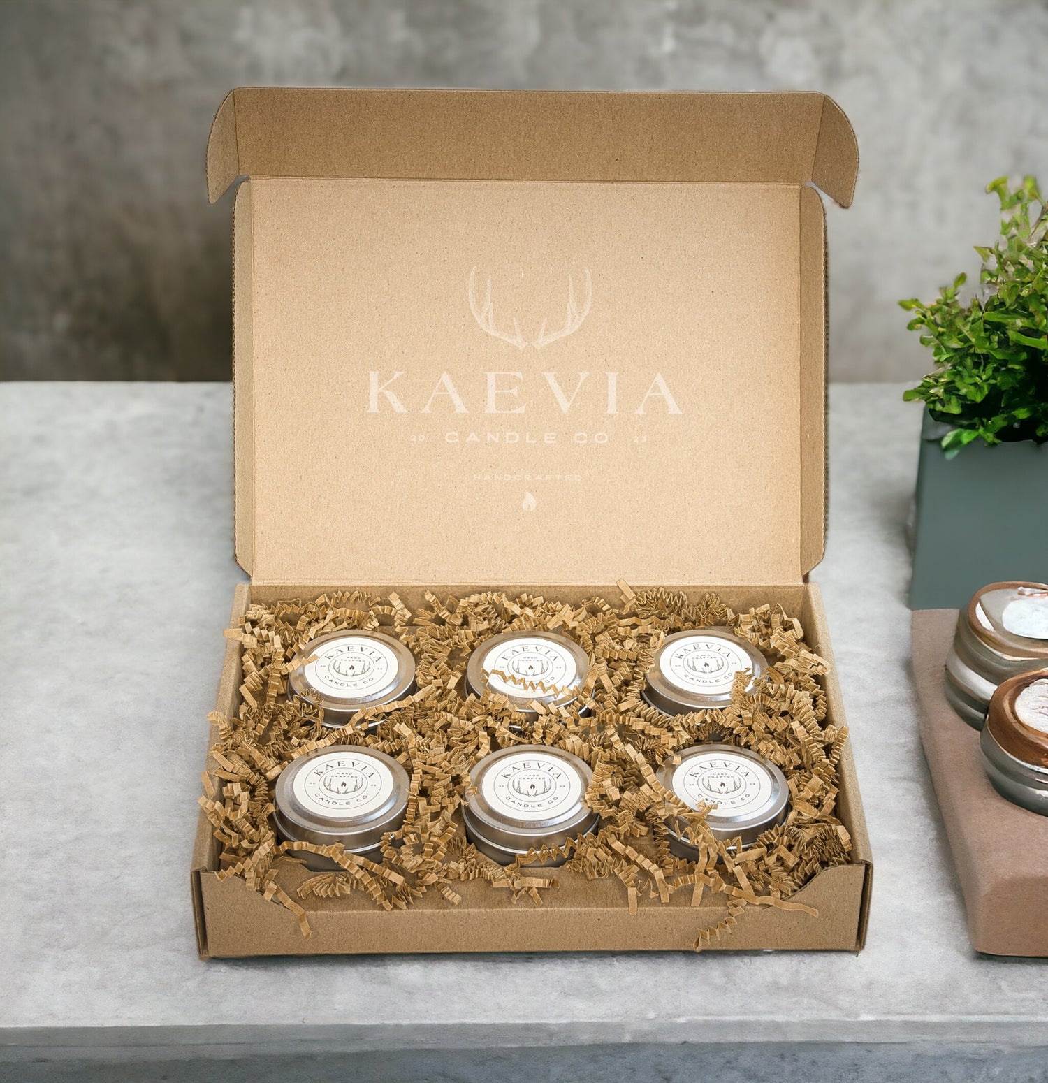 6 small tin jars in a gift boc sitting on a concretetable
